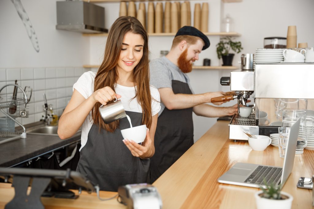 Coffee Business Concept Close Up Lady Barista In Apron Preparing And Pouring Milk Into Hot Cup While Standing At Cafe.